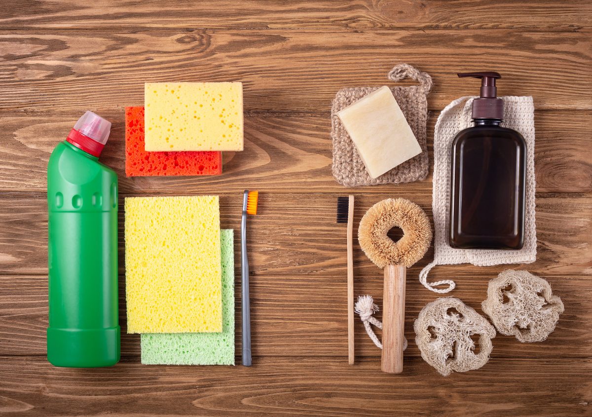 Conventional and eco-friendly cleaning products laid out on a wooden surface